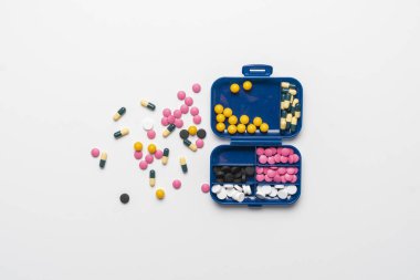 Tedavi için bir sürü renkli hap ilacıyla dolu plastik ilaç kutusu.