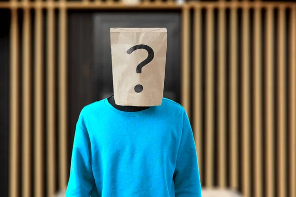 Pessoa com um saco de papel na cabeça com ponto de interrogação, símbolo de sinal de problema — Fotografia de Stock