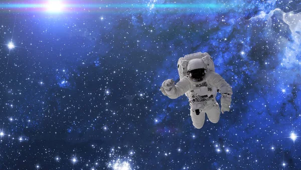 A cosmonaut fly in the outer space with stars and galaxy background with a light beam. elements of this image furnished by nasa — Stock Photo, Image