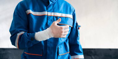 Üniformalı bir sanayi işçisi. Kazada yaralanmış. İlk yardım.