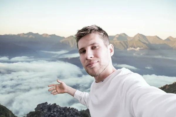 Mladý muž na horách, který dělá autoportrét na vrcholu hory — Stock fotografie