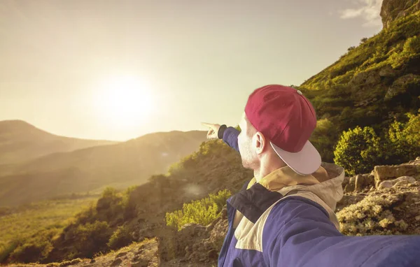 Um jovem caminhando pela montanha, fazendo um auto-retrato no pico da montanha — Fotografia de Stock