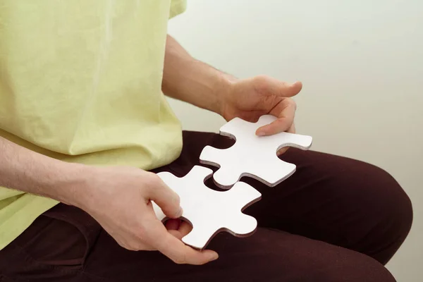 Una persona sosteniendo y conectando pizzles del rompecabezas, resolviendo el problema — Foto de Stock
