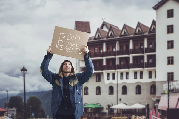 Чоловік молодий активіст з картоном, сольний протест, політичний жест, показує плакат — стокове фото