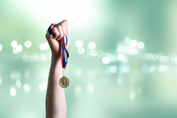 Uma pessoa levantou a mão ganhando o primeiro lugar, mão segurar medalha de ouro — Fotografia de Stock