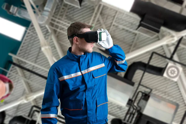 Egy férfi munkás egyenruhában virtuális valóság szemüveggel, új technológiai szemüveggel — Stock Fotó