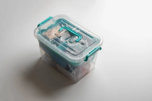 Uma caixa de plástico transparente com algumas coisas em casa — Fotografia de Stock