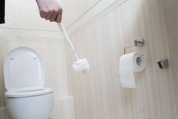 Een hand met een borstel schrobben en het reinigen van het toilet — Stockfoto