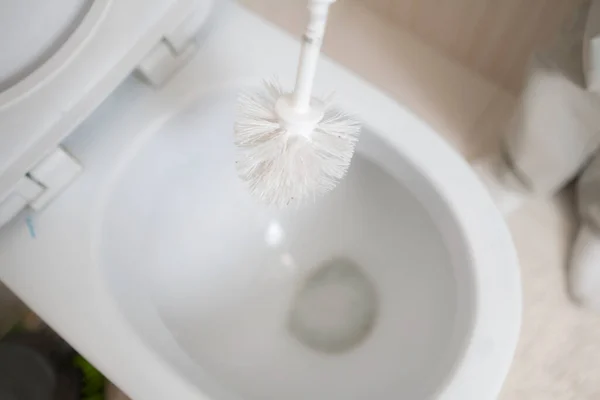 Uma mão segurando uma escova esfregar e limpar o banheiro — Fotografia de Stock