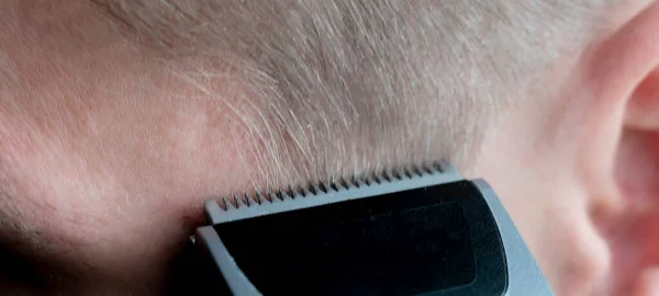 Un maestro macro de cerca haciendo un corte de pelo sosteniendo un cortador o recortador para cortar el cabello —  Fotos de Stock