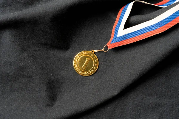 Uma medalha de ouro para o primeiro lugar recompensa, sucesso no conceito de competição — Fotografia de Stock