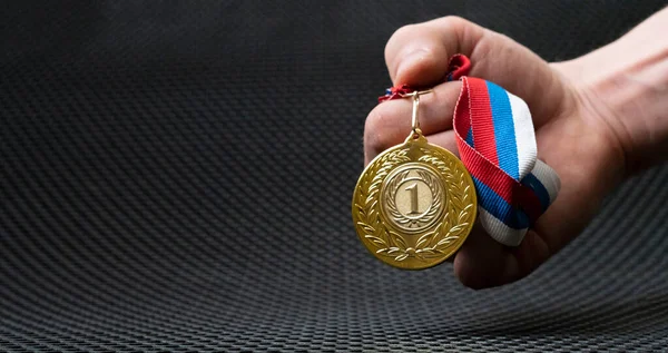 Рука таборів тримає золоту медаль, простий переможець пощастило концепції — стокове фото