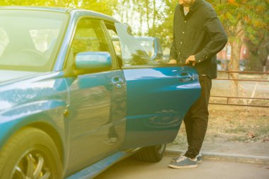 Mavi arabanın kapısını açan kişi içeride oturur, otomatik yolculuk başlar.