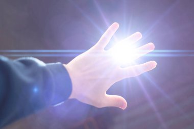 Karanlık bir gecede bir insan elini ışıktan korur. Korku gizemi.