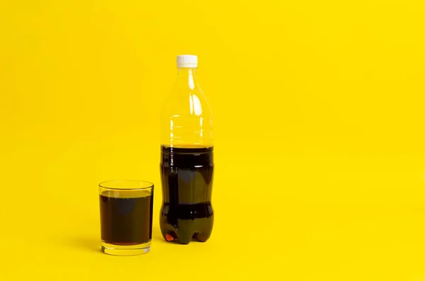 Черный лимонад налили в стакан, бутылка соды изолированы на цветном фоне — стоковое фото