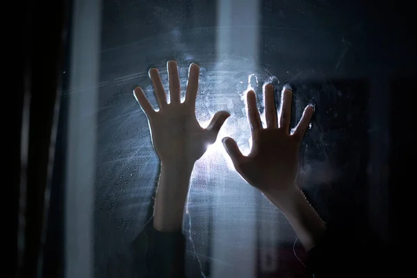 Una inquietante scena dell'orrore, persone mani nel buio dietro il vetro, paura ombra astratta — Foto Stock