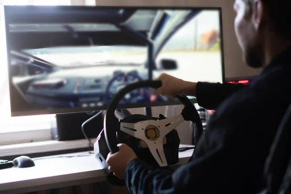 Uma pessoa aprende como dirigir o carro usando um simulador de computador automático — Fotografia de Stock