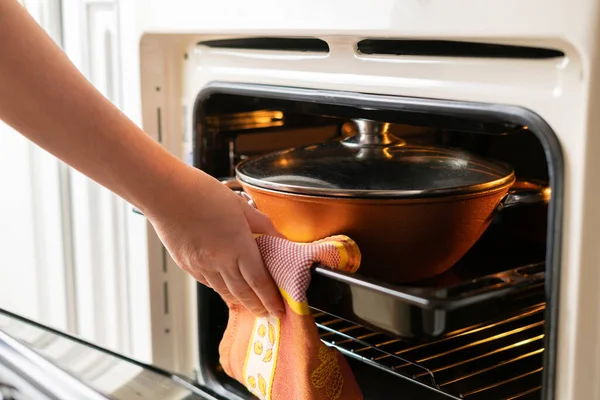 Een close-up vrouw handen open de oven en neem verse gekookte voedsel thuis — Stockfoto