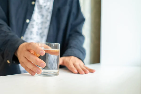 A feeling thirsty in the early morning, persons hand taking a glass of water from the table — Stockfoto