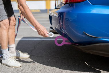 Çekici halatı tutan adam araba kancasına takıyor, araba kazası ve motor arızası.