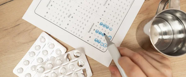 A personen hand holding pillen, het maken van het schema op de kalender, gezondheidszorg — Stockfoto