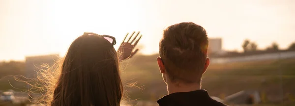 一对年轻夫妇看着天空，用手捂住太阳，阳光灿烂 — 图库照片