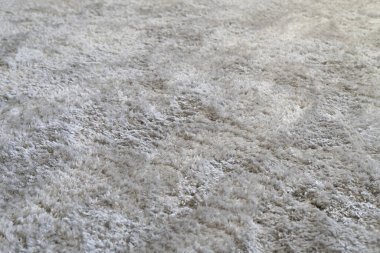 Evde, oturma odasında, yerde temiz beyaz bir halı, tekstil dokusu.