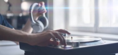 Yakın çekim bir insan eli bir plağa iğne koydu, partide vinil disk çaldı.