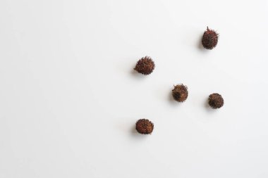 Rengarenk masanın üzerine biraz Rambutan meyvesi damlası izole, basit minimalist stil, yukarıdan görünüm, düz uzanış