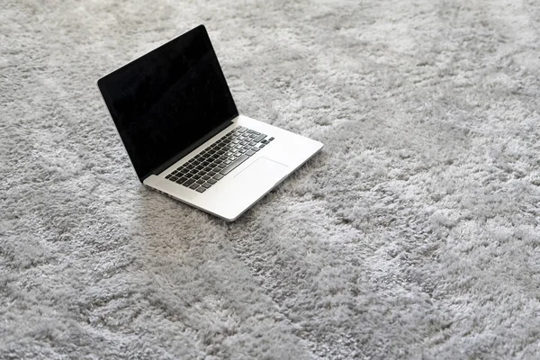 A laptop and other devices on the floor on the soft carpet in living room at home, isolation during coronavirus pandemy — Stok Foto