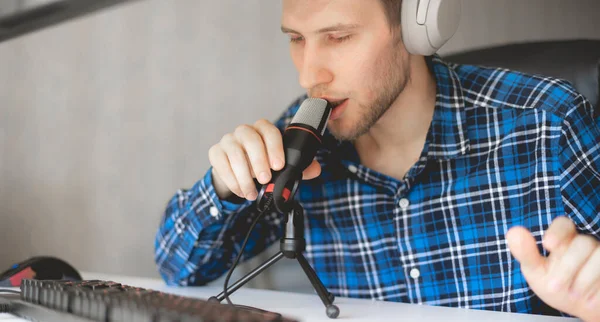 A young male handsome host recording podcast in the studio, streaming live — Stockfoto