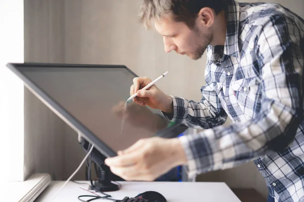 Um jovem artista digital masculino desenhando tinta no monitor de tela do computador em estúdio — Fotografia de Stock