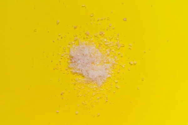 Een snufje grof zeezout geïsoleerd op het kleurrijke oppervlak, gezonde voeding — Stockfoto