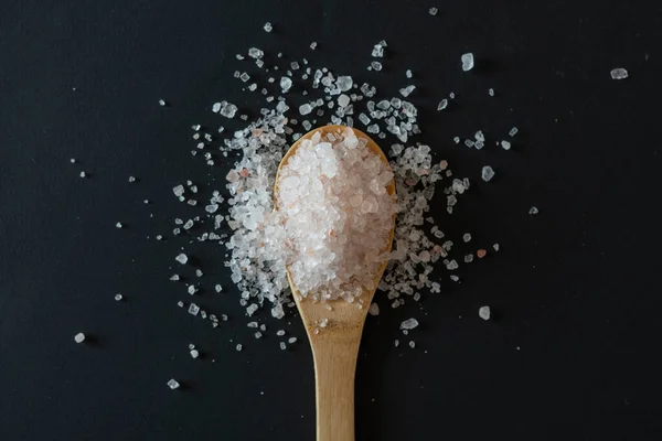 Ξύλινη κουτάλα με θαλασσινό αλάτι στο τραπέζι, top view απομονωμένη — Φωτογραφία Αρχείου