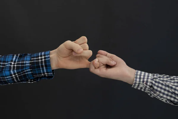 A close up two people hook little fingers of each other, isolated, simple relationship concept —  Fotos de Stock