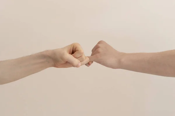 Egy közeli kép két ember horog kis ujjak egymást, elszigetelt, egyszerű kapcsolat koncepció — Stock Fotó