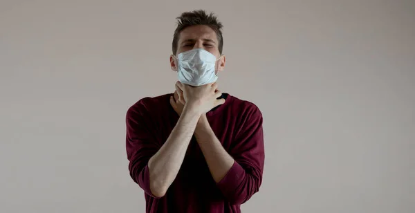 A male person holding a throat while choking and can not breathe, isolated against the wall, coronavirus concept in china wide webn banner — Fotografia de Stock