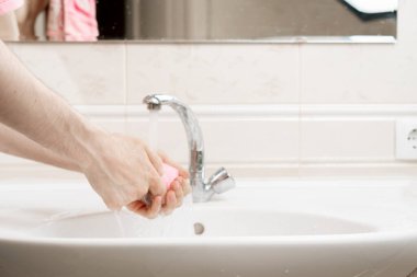 Kişisel hijyen kuralları, elinde sabun tuğlası olan ve kirli ellerini yıkayan kişi, Coronavirus covid koruması.