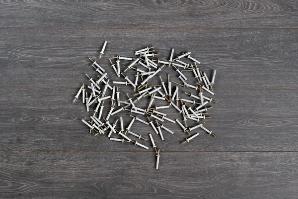 Felülnézetből a csomó fém acél csavar vagy tipli műanyag kupakkal elszigetelt asztalon — Stock Fotó