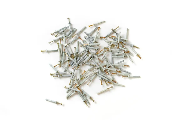 Felülnézetből a csomó fém acél csavar vagy tipli műanyag kupakkal elszigetelt asztalon — Stock Fotó