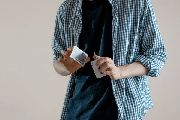 Osoba trzymająca karty do gry i robiąca magiczną sztuczkę skupiająca się, stojąca na ścianie — Zdjęcie stockowe