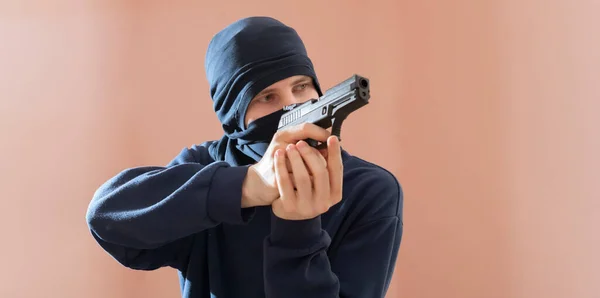 Una persona masculina irreconocible en la máscara negra y pistola, fuera de la ley y el concepto del crimen amplia bandera webn —  Fotos de Stock