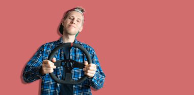 Genç bir adam direksiyonu tutar ve kendini bir yarış pilotu olarak hayal eder.