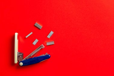 Basit bir zımba ve zımba ofis masasının renkli arka planında izole edilmiş.