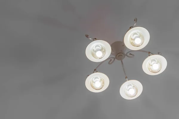 Een close-up grote home licht kroonluchter tegen het plafond uitzicht thuis, minimalistische stijl — Stockfoto