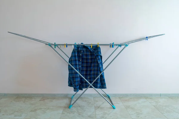简单可折叠机架烘干机，带有干净的洗涤过的纺织品，烘干过的衣服 — 图库照片