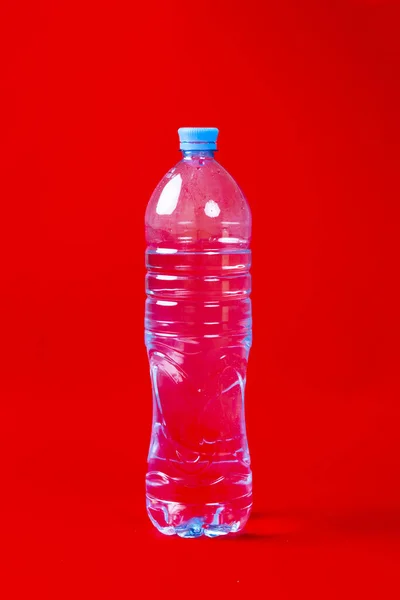 Простая пластиковая бутылка с чистой водой на красочном фоне — стоковое фото
