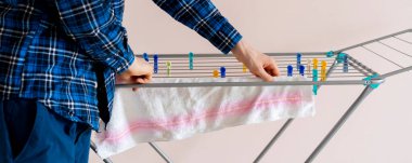 Evdeki elbise askısına yeni temiz giysiler asıyorum.