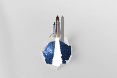 Bir uzay mekiğinin yaratıcı görüntüsü kağıttan bir delikte uçar, yıldızları yakalar bu görüntünün unsurları NASA tarafından desteklenir.