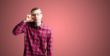 Gözlüklü, kareli gömlekli bir erkek, gözlüklü ve hastanede göz muayenesi yapıyor.